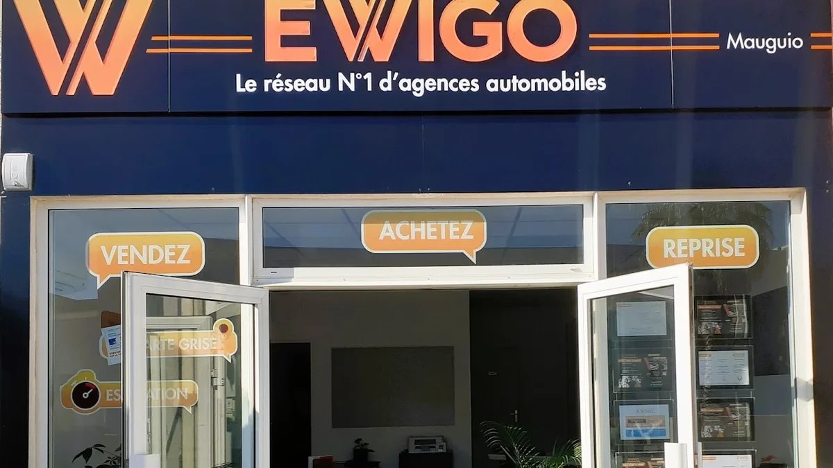 Façade de l'agence Ewigo Mauguio, portes ouvertes, avec les vitrines Vendez, Achetez, Reprise